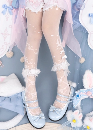Overhead flat shot of white Lolita floral sheer tights featuring delicate bird and floral prints with lace ruffle ankle cuffs and matching bows, styled with pastel Lolita skirt and blue Mary Jane shoes with bunny hair accessories
