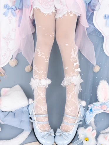 Overhead flat lay of white Lolita floral sheer tights with snowflake and vine botanical patterns, lace ruffle ankle cuffs featuring decorative bows, modeled with pastel Lolita skirt, blue Mary Jane shoes, cat ear hair props