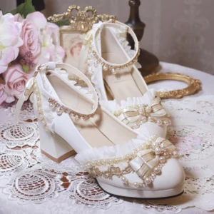 Handcrafted white bridal Lolita heel shoes side top view showing detailed vamp ruffled ankle strap and satin bow with pearl accents on lace-covered table