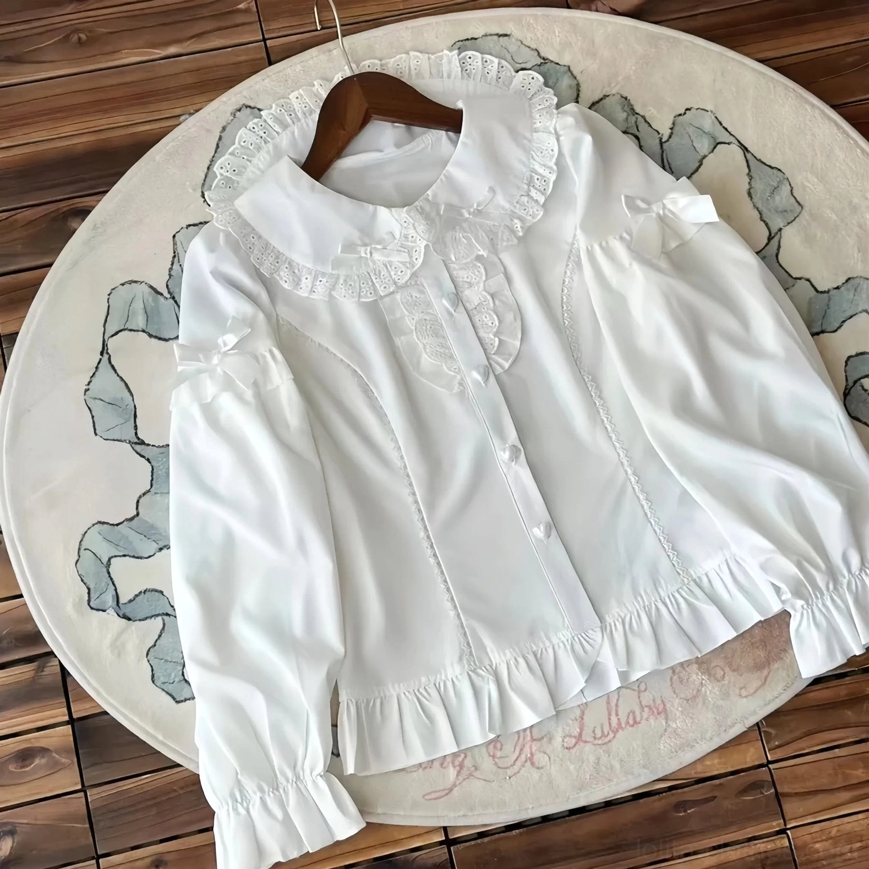Long sleeve white peter pan collar lolita blouse flat lay lace ruffled collar cuffs hem front button closure shoulder bow detail
