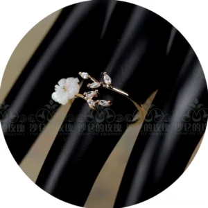 White mother-of-pearl flower Classical Lolita adjustable ring with crystal leaf accents displayed on black jewelry hand model
