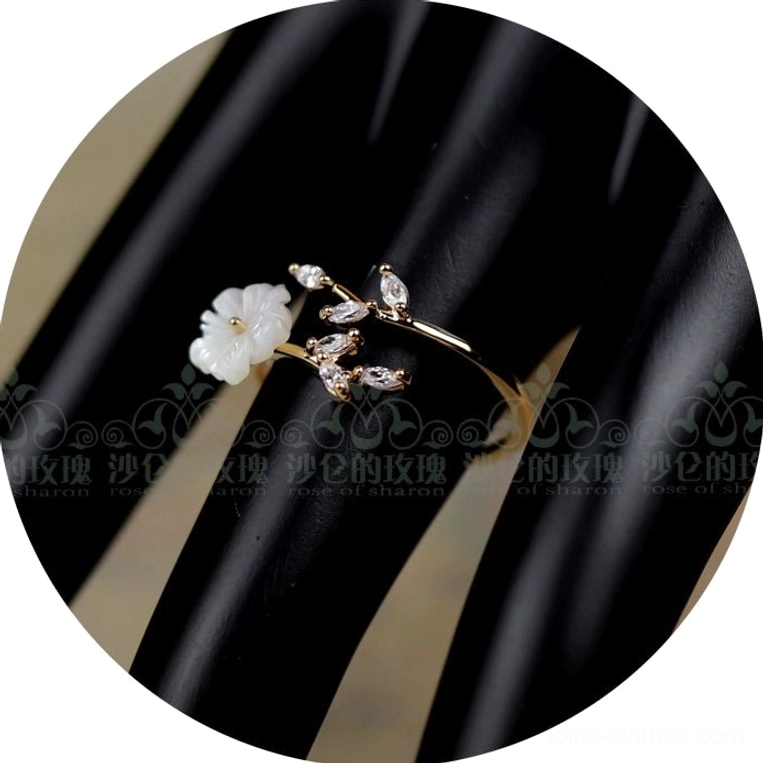 White mother-of-pearl flower Classical Lolita adjustable ring with crystal leaf accents displayed on black jewelry hand model