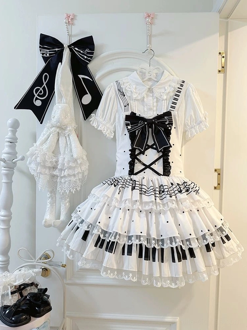White Musical Lolita Salopette Dress with Black Cross Straps and Front Bow - Indoor Display with Polka Dot Skirt Details and Lolita Shoes