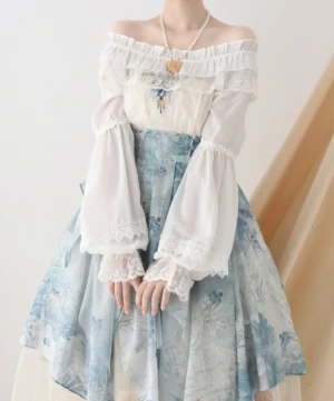 Off-shoulder classic Lolita blouse in white chiffon with lace-trimmed bell sleeves worn with blue printed Lolita skirt and pendant necklace front view