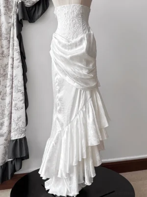 White Oracle gothic lolita mermaid skirt with lace-trimmed corset and asymmetrical ruffled fishtail hem on display