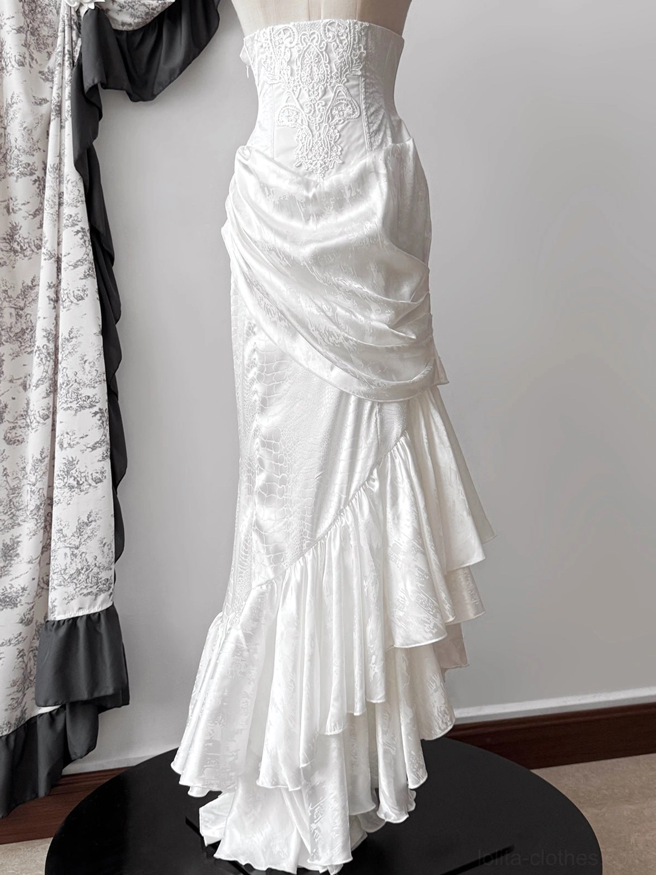 White Oracle gothic lolita mermaid skirt with lace-trimmed corset and asymmetrical ruffled fishtail hem on display