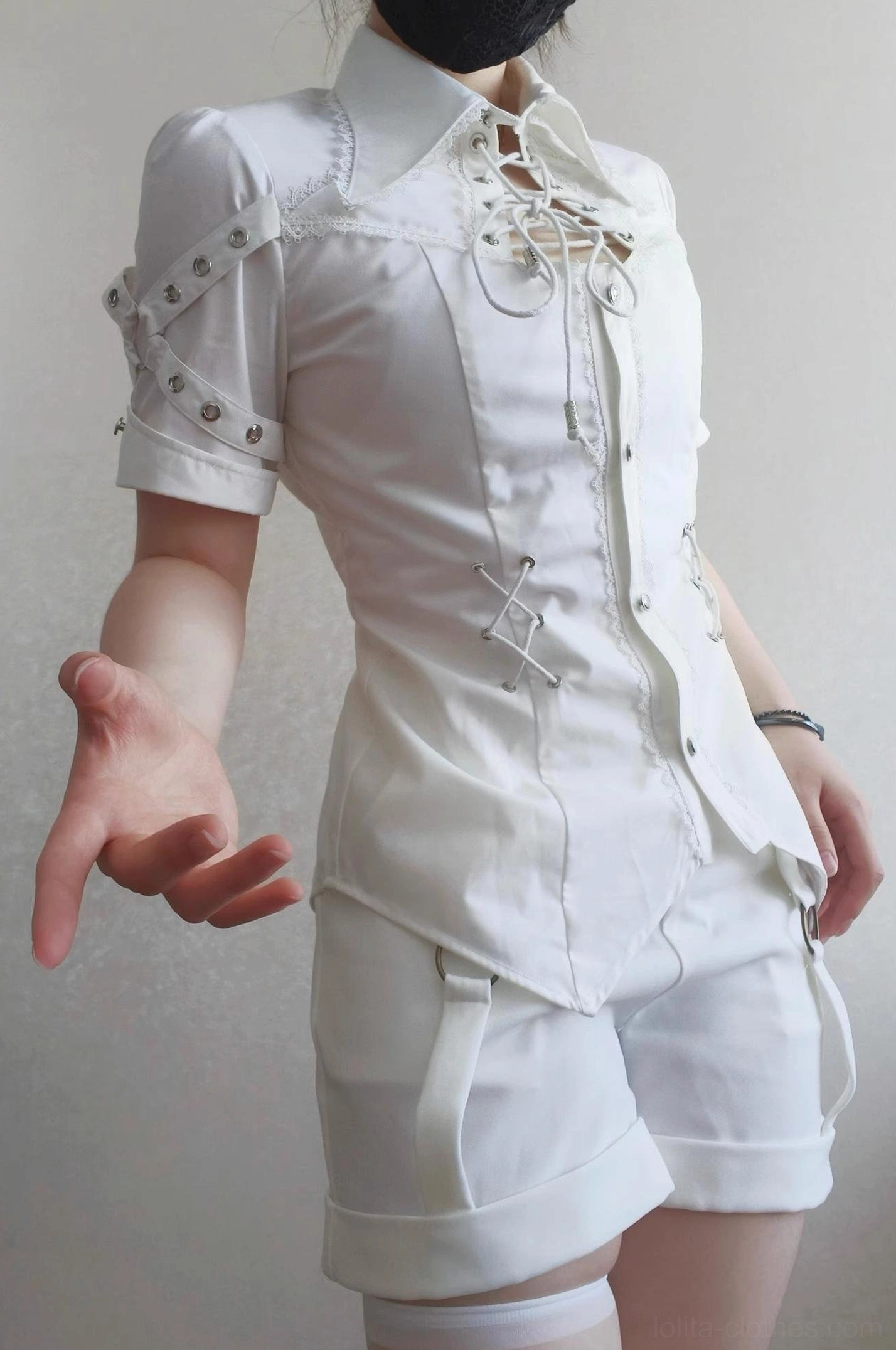White Ouji Lolita blouse and shorts two-piece set half-body front view on model wearing white thigh-high stockings, showing pointed collar, front lace-up closure, buttoned front, decorative shoulder strap details on short sleeves with fitted waist cut