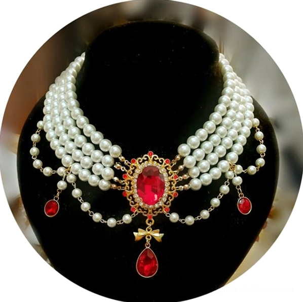 White pearl Gothic choker necklace front close-up view on black velvet jewelry mannequin, displaying white pearl strands, large red central gem, ornate gold cross pendants, and dangling teardrop crystal with pearl details