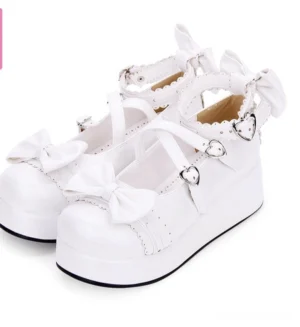 White pearl silver-toned sweet Lolita platform Mary Jane shoes three-quarter side view featuring crisscross ankle straps and vamp bow accent