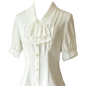 White short-sleeve Lolita blouse with Peter Pan collar detailed close-up flat lay front view showing ruffled jabot lace trim button closure and smooth silky fabric texture