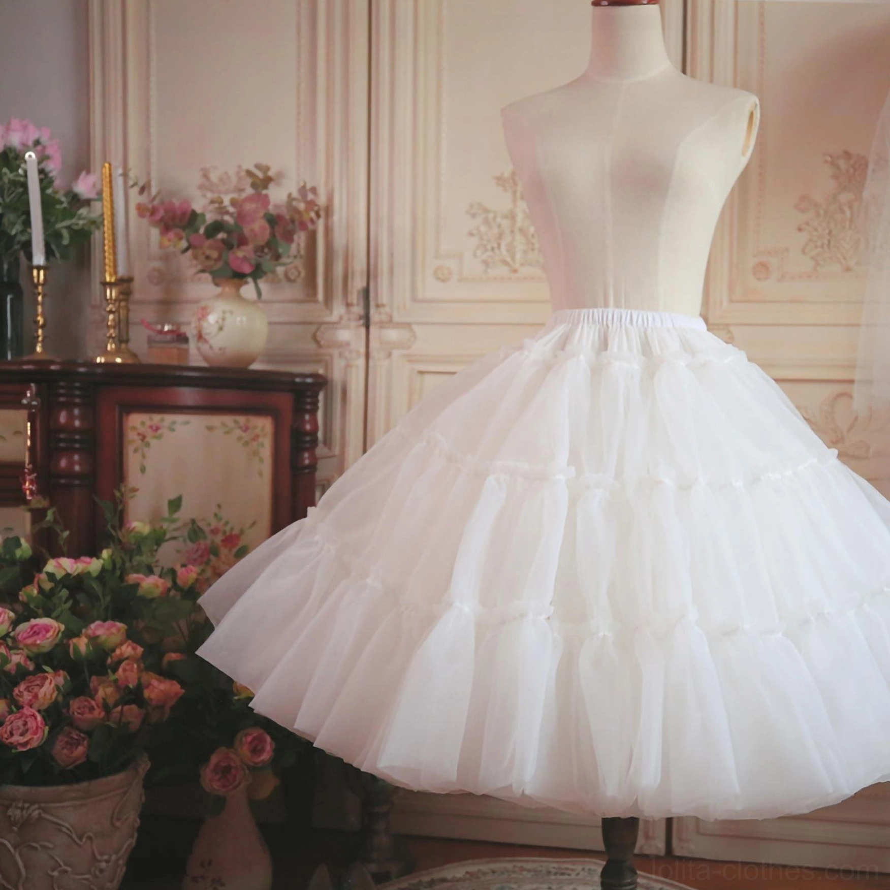 White fluffy petticoat direct front full-length view on dress mannequin, displaying complete A-line puffy shape, classic tiered tulle skirt structure, vintage flower vase decor