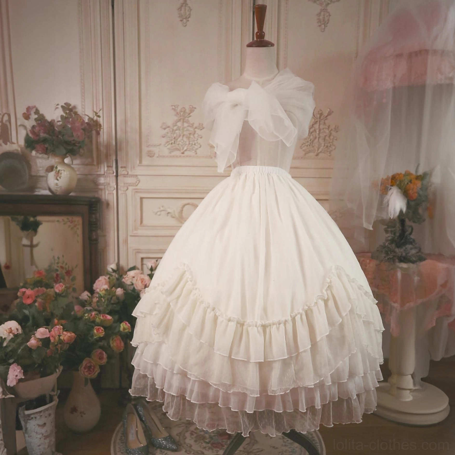 Back three-quarter view of white ruffled petticoat on mannequin with back bow decoration, showing multi-layered ruffled skirt hem and extreme volume structure