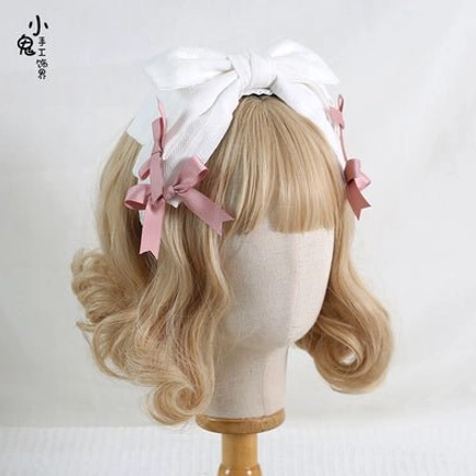 White oversized bowknot lolita hair headband with four pink satin bow accents on blonde mannequin head white textured background