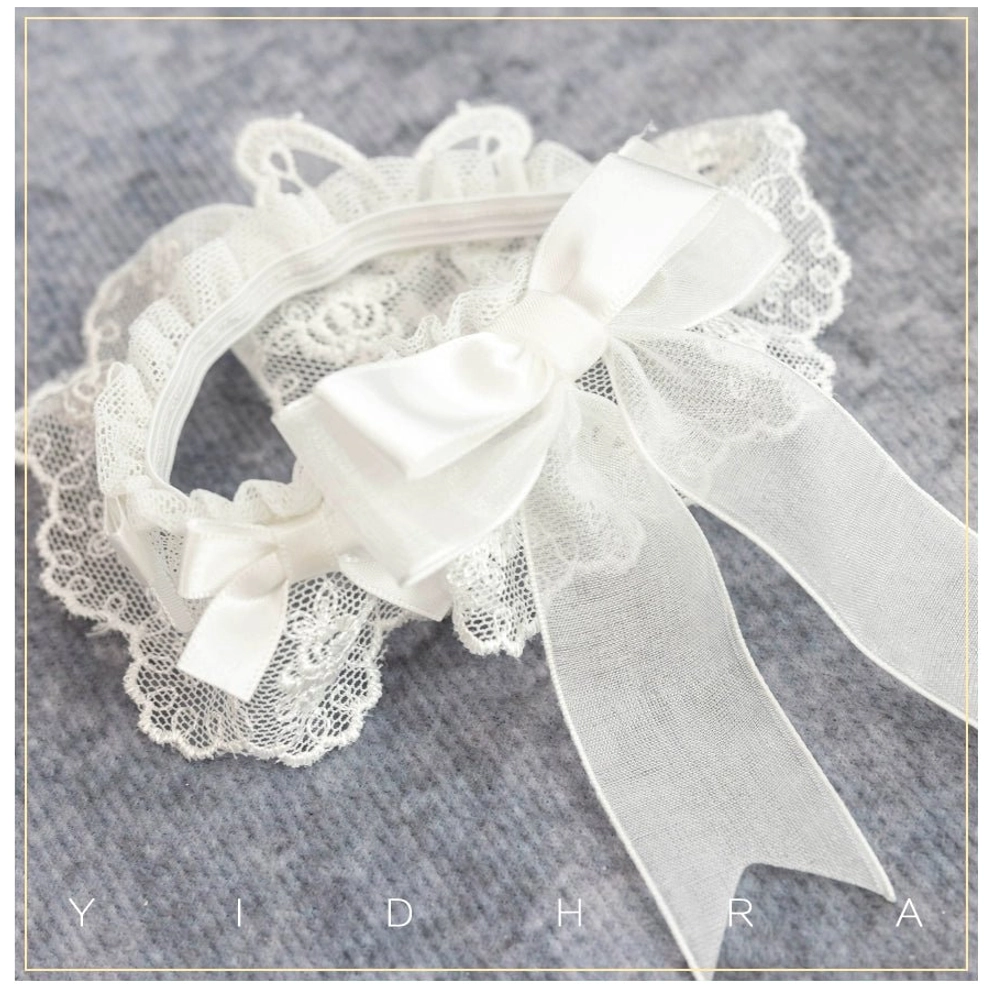 White removable Lolita sock cover accessory with ruffled lace edge large satin bow and pure white lace design flat lay on grey background