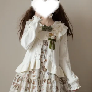 white solid lolita cardigan with ruffled collar close-up front view paired with vintage green bow brooch and printed dress