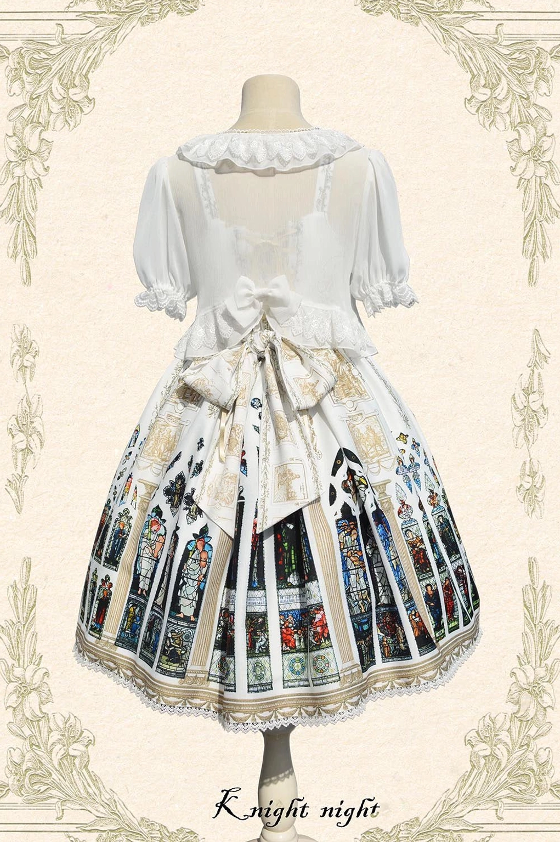 Back view of White Saint Priest Lolita coordinate showing double large back bows on JSK, ruffled Peter Pan collar bolero, sheer puff sleeves, and stained glass print skirt