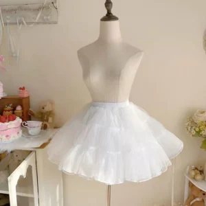 White boneless soft yarn Lolita petticoat displayed on dress mannequin with 4-layer ruffled tulle creating full A-line silhouette, shown in warm vintage home setting with teacup and dessert styling