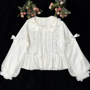Milky white sweet Lolita blouse with Peter Pan collar and double-layered puff sleeves featuring front lace pintucks, sleeve bows and ruffled cuffs - flat lay overhead view with artificial roses on black background