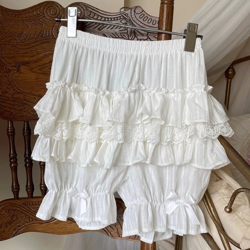 Pure white sweet lolita cotton bloomers displayed hanging vintage wooden chair clothes hanger multi-layer ruffled lace trim satin bows leg cuffs front view
