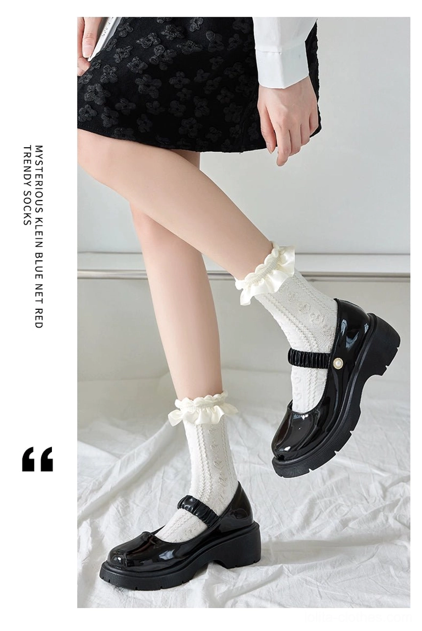 White Sweet Lolita mid-calf socks featuring ruffled ankle cuff and twisted knit fabric texture worn with patent leather Mary Jane shoes three-quarter view