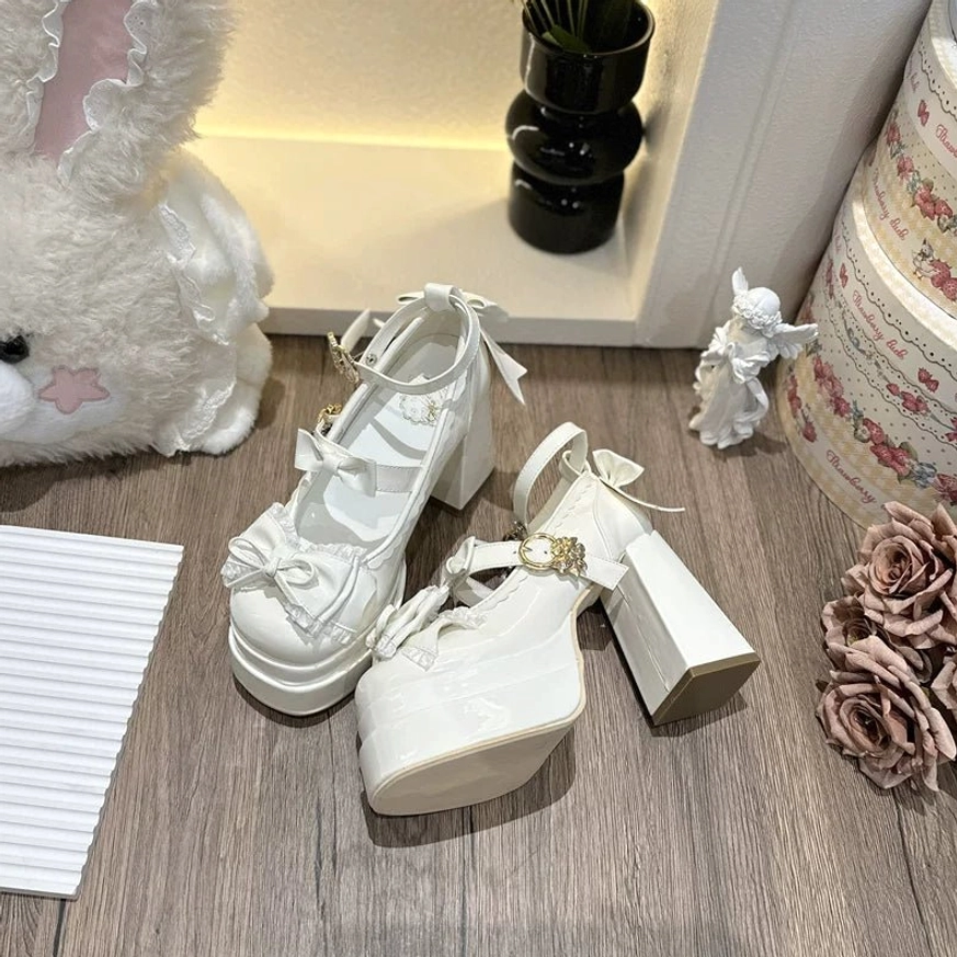 White sweet Lolita platform heel shoes flat lay display glossy patent leather with bows ruffles and decorative hardware details