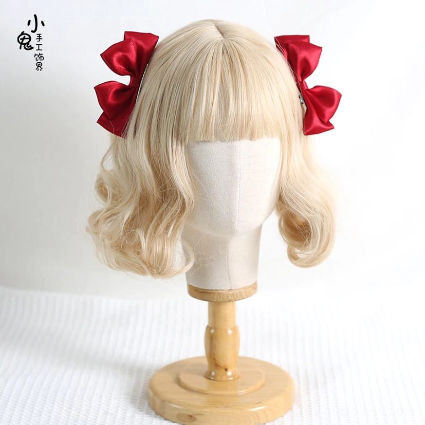 White Sweet Lolita satin bow hair clips on blonde curly wig with wooden display stand showing bright white satin material and matched paired hair accessories