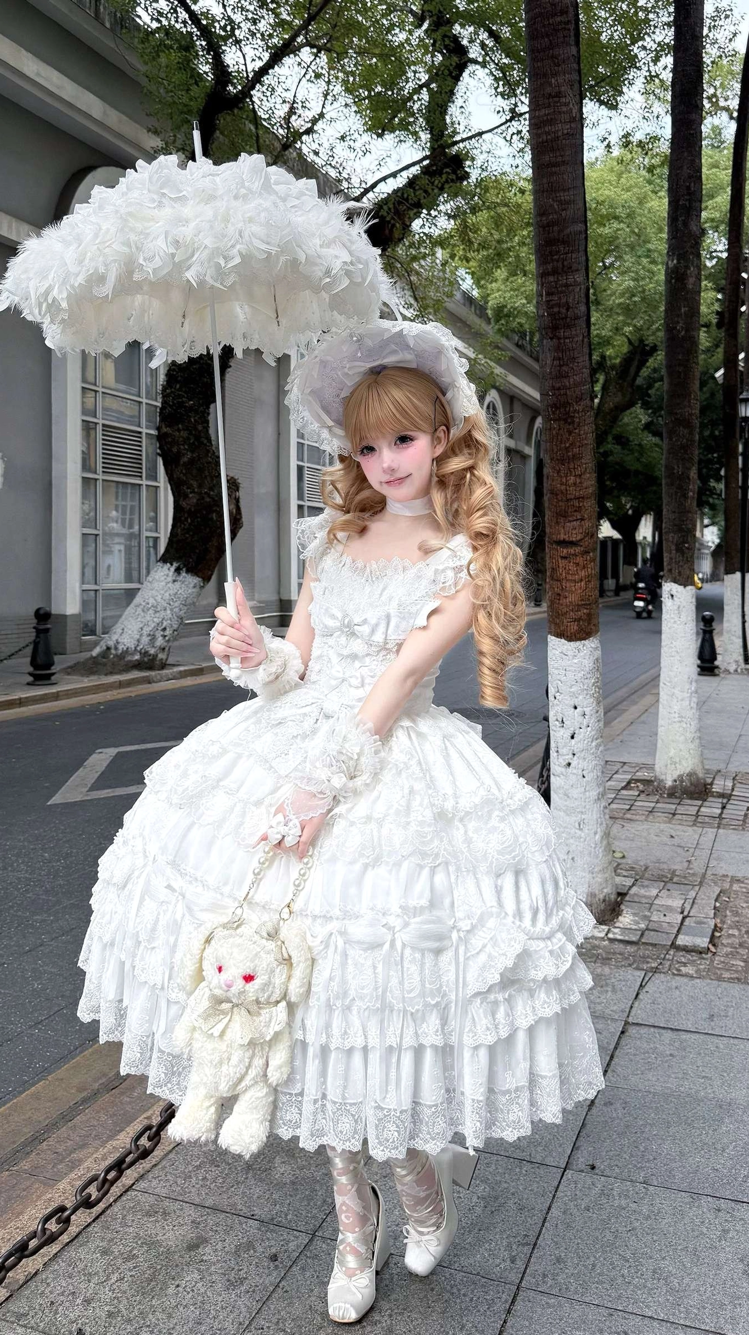 Full length view of white sweet lolita tiered JSK dress with multi-layered lace cake skirt and matching bonnet accessory