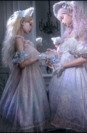 Close-up side view of two lolita models featuring off-shoulder ruffled sleeves, sheer tulle overlay skirts, and delicate lace details with coordinating headdresses under chandelier decor