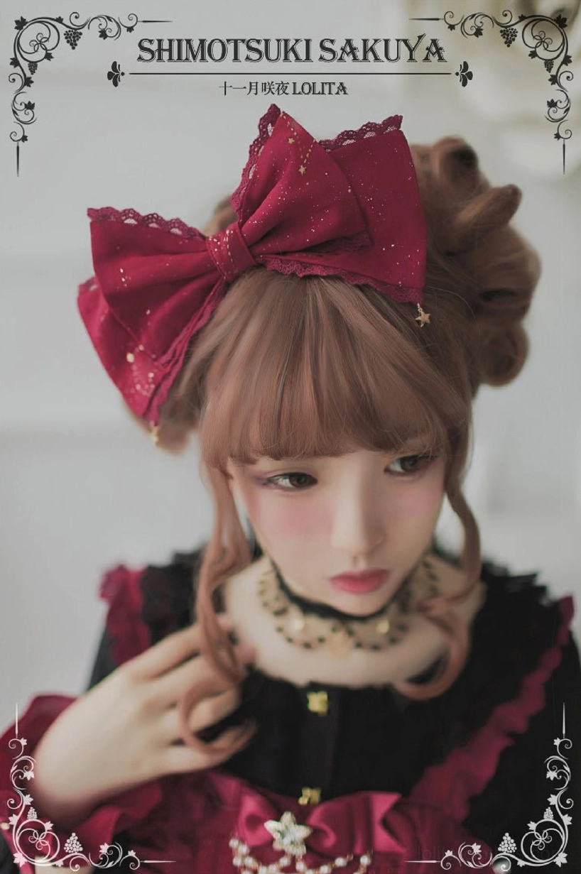 Wine red burgundy vintage Lolita bow headdress with glittery finish and tiny star pendants worn by model in matching red Lolita dress