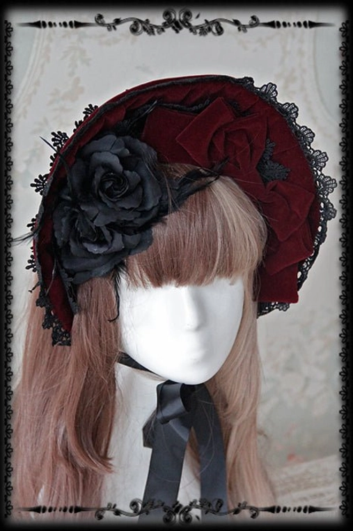 Wine red velvet Gothic Lolita bonnet with black ruffled lace brim and large black rose fabric bow decoration, front view wearing
