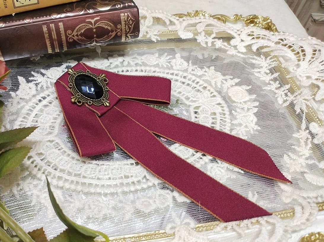 wine-red-lolita-bow-brooch-gold-edging-vintage-oval-black-gemstone-bronze-metal-frame-white-lace-doily-vintage-books-roses-flatlay