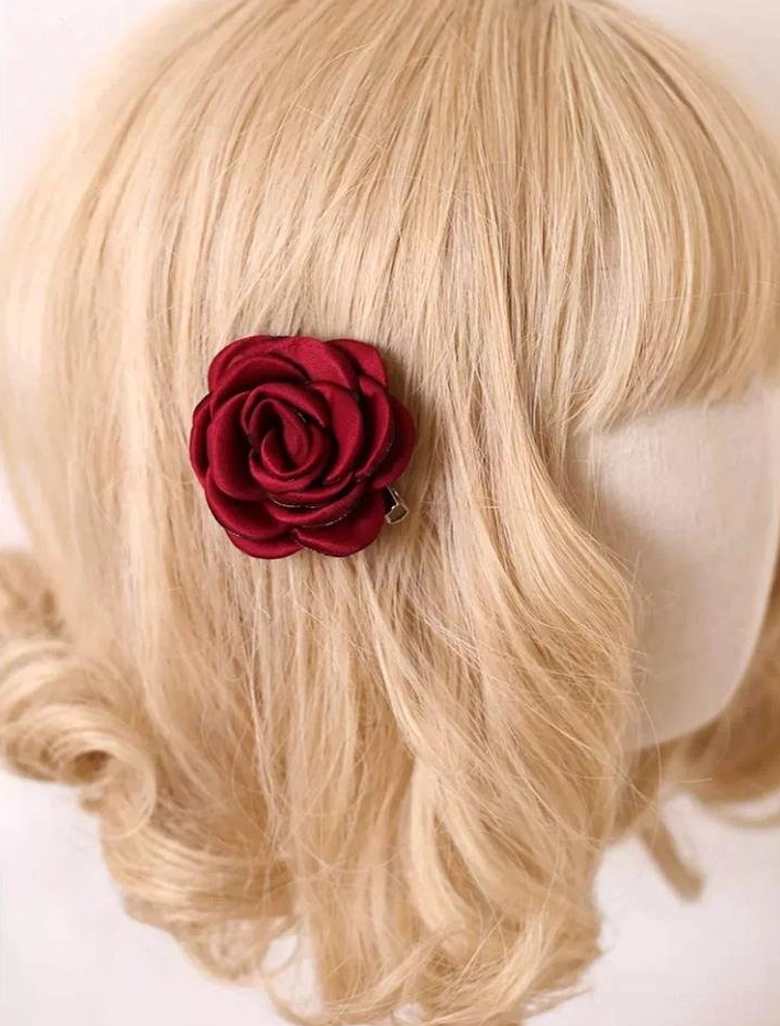 Close-up side view of wine red fabric rose hair clip on blonde Lolita mannequin head showing secure clip backing mechanism