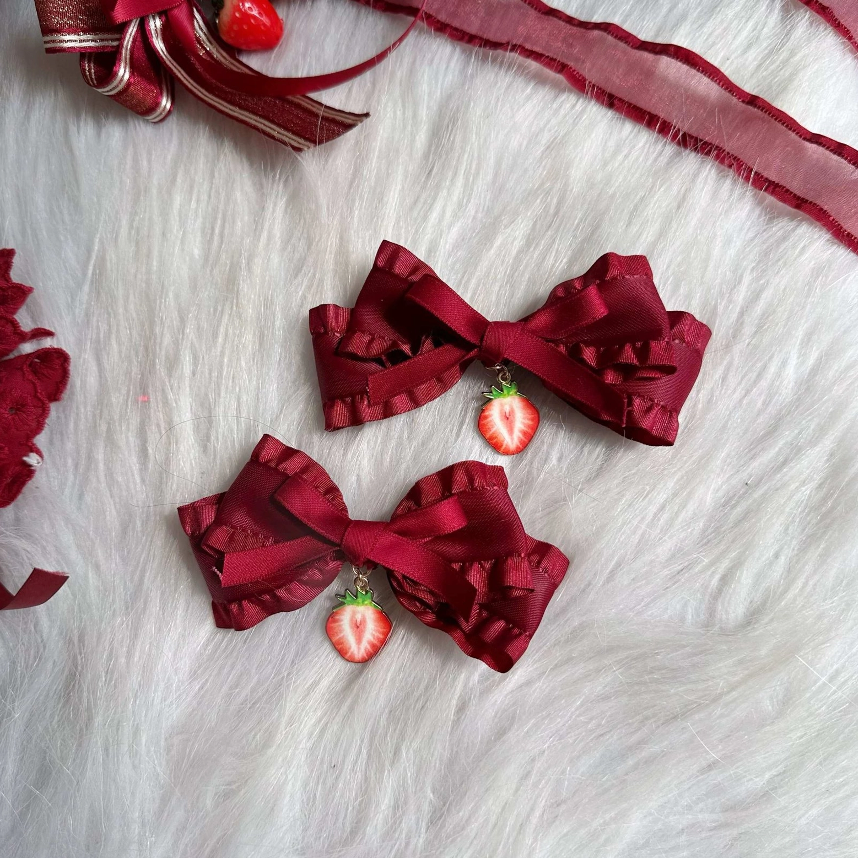 Pair of solid wine red ruffled satin bow lolita hair clips with small strawberry pendants