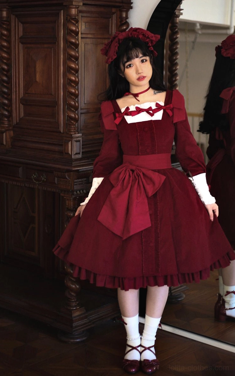 Burgundy wine red velvet classic Lolita OP dress with square neckline, front-facing full body portrait showing large waist bow and ruffled skirt hem with white cuffs and chest decorations