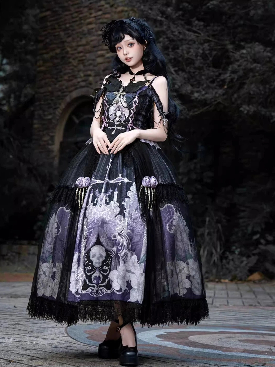 Withered Bone Gothic Lolita dress set front three-quarter view on model wearing black-purple skeleton floral jacquard coordinated ensemble with adjustable straps and tiered tulle skirt in vintage stone courtyard setting