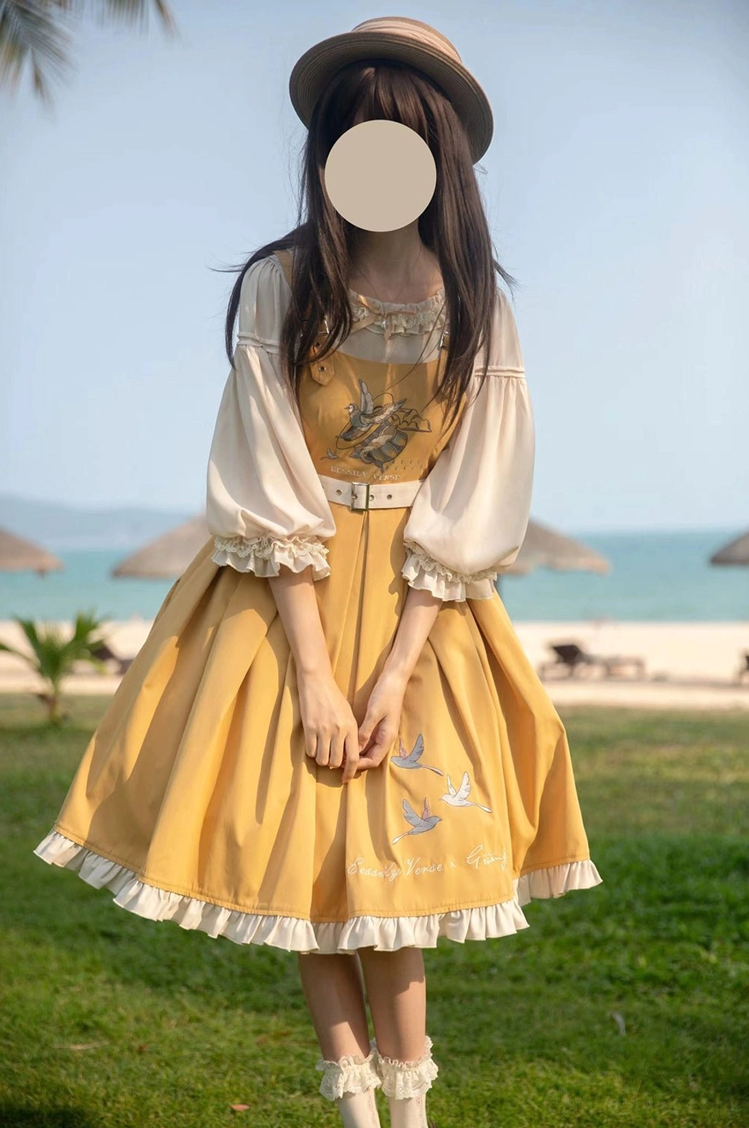 Yellow bird embroidery Lolita JSK dress with inner blouse half-body front standing pose beach seaside outdoor background lace-trimmed lantern sleeves detachable waist belt