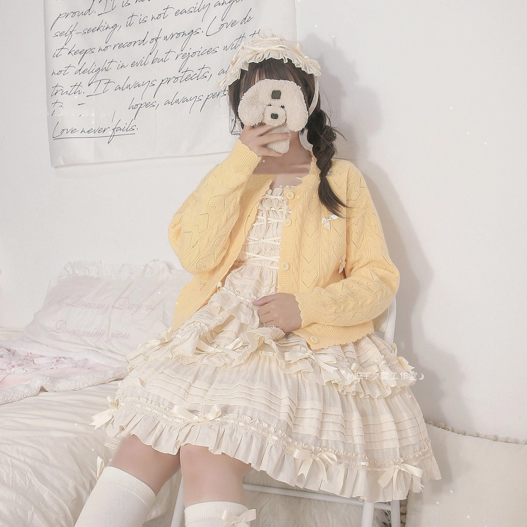 Yellow hollow out Lolita cardigan and ivory ruffled Lolita dress sitting shot, showing lace-trimmed details and loose fit cardigan silhouette, bedroom bed background
