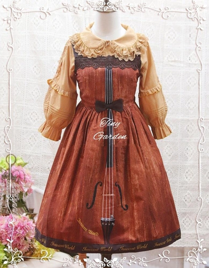 Mustard yellow ruffled sleeve Lolita blouse coordinated with burgundy violin printed Lolita skirt and black bow trim on dress form display