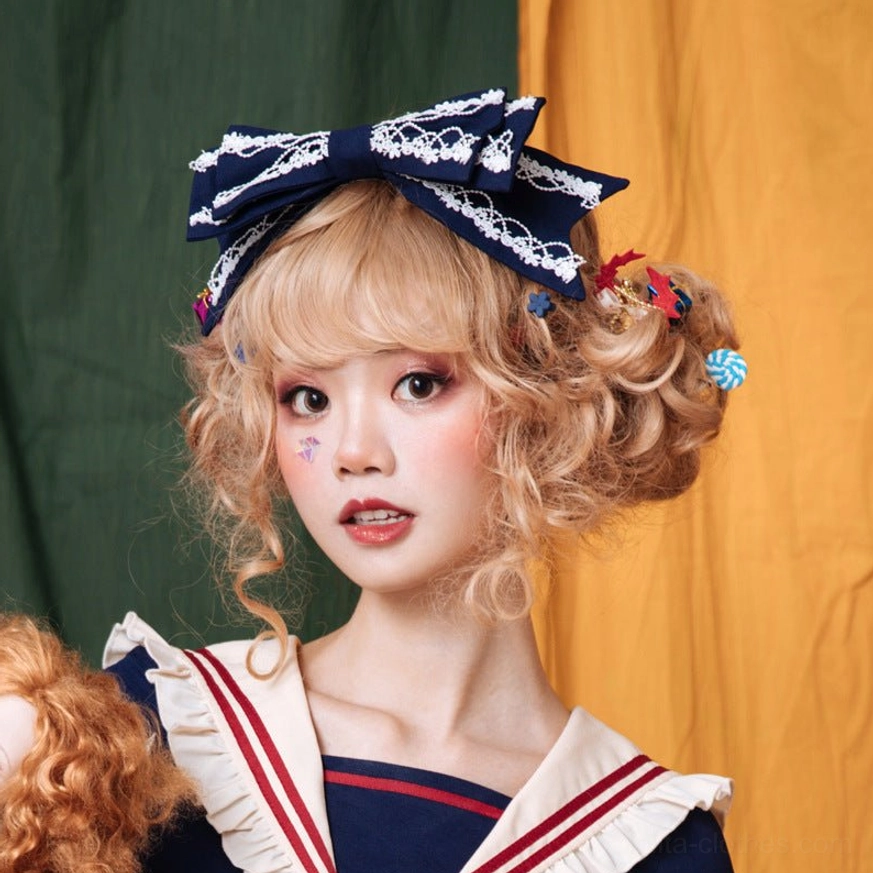 Yellow sweet lolita bow KC headband with white lace edging on brown-haired model in sailor dress